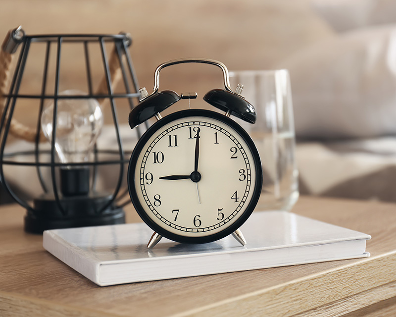 alarm clock and glass of water for medication management
