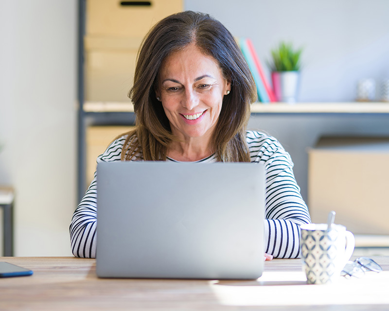 Woman sitting at a laptop having telehealth psychiatry appointment